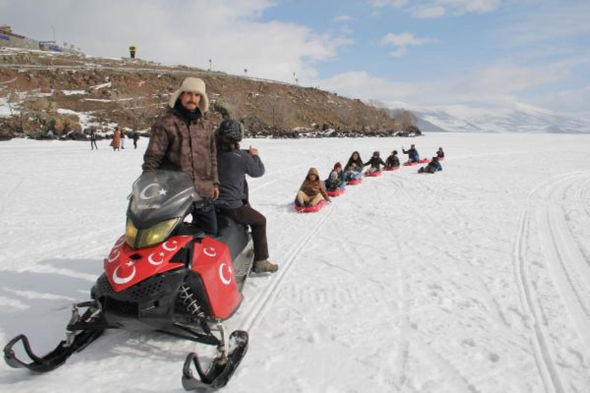 Çıldır Gölü'nde çocuklar, kar motosikletinin arkasına vagon yaptılar 