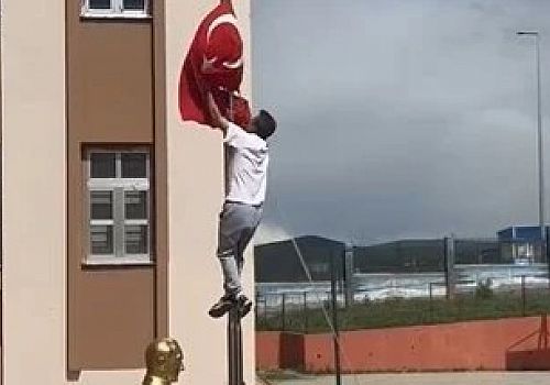 Ardahan'da okul önünde direğe dolanan bayrağı tırmanarak çözen beden öğretmeni, veliler ve öğrencileri tarafından büyük alkış aldı.