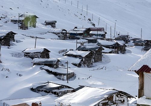 Ardahan'ın yüksek kesimlerinde bulunan yayla evleri karla kaplandı.