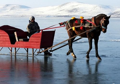 Çıldır Gölü üzerinde, türkü eşliğinde atını buza alıştırıyor