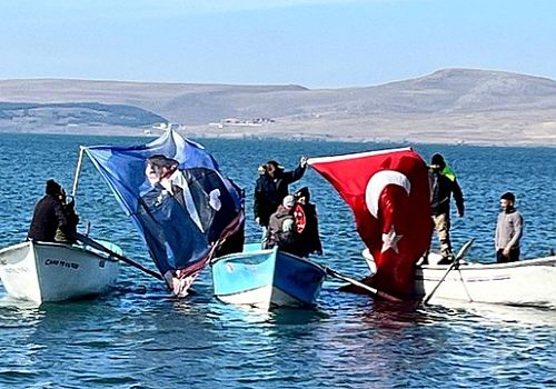 Çıldır Gölündeki Balıkçılar Atatürk posteri ve Türk bayrağı açarak saygı duruşunda bulundu.