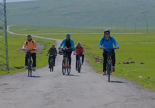 Göle'de bisiklet tutkunları çiçeklerle kaplı ovada pedal çevirerek doğanın güzelliklerini tanıttı